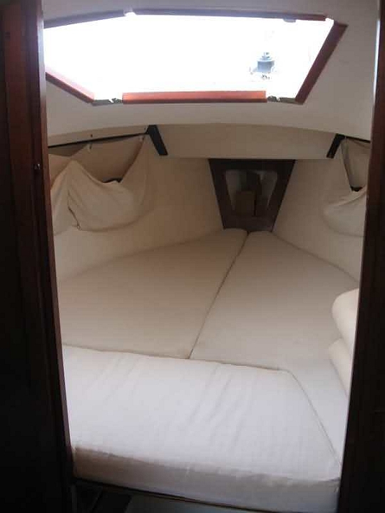 peinture pont 2008b 002.jpg - cabine avec matelas en position couchage deux adultes: on apercoit un peu de part et d'autres les équipets en tissu suspendus qui servent de rangements à habits très efficaces et qui laissent toute le largeur disponible